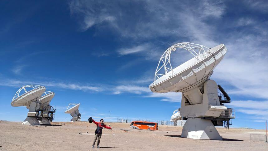 Hanae Inami at the Atacama Large Millimeter Array (ALMA), Chile, next to the radio telescopes that comprise the interferometric array. (Photo courtesy of Hanae Inami)